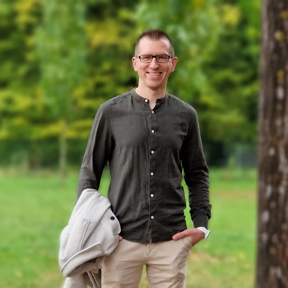 Tobias Falkenroth – Porträt vor grünem, unscharfem Hintergrund